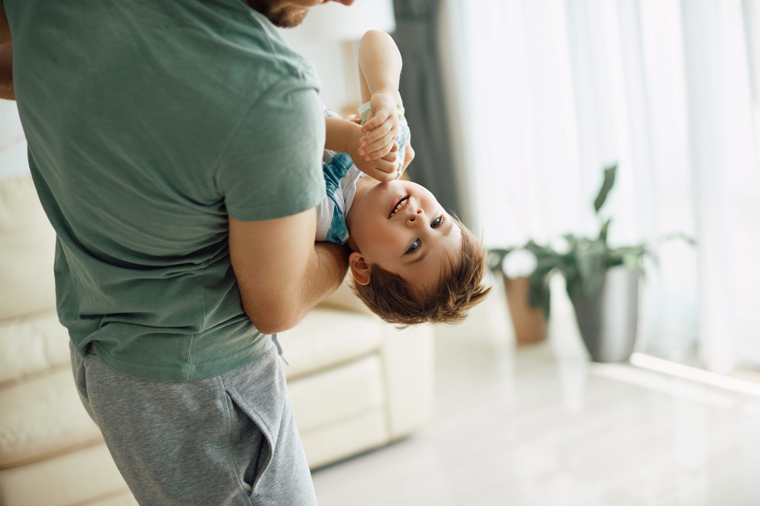 Un bambino felice con il padre che lo tiene in braccio.